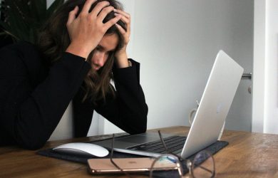 a woman sitting in front of a laptop computer
